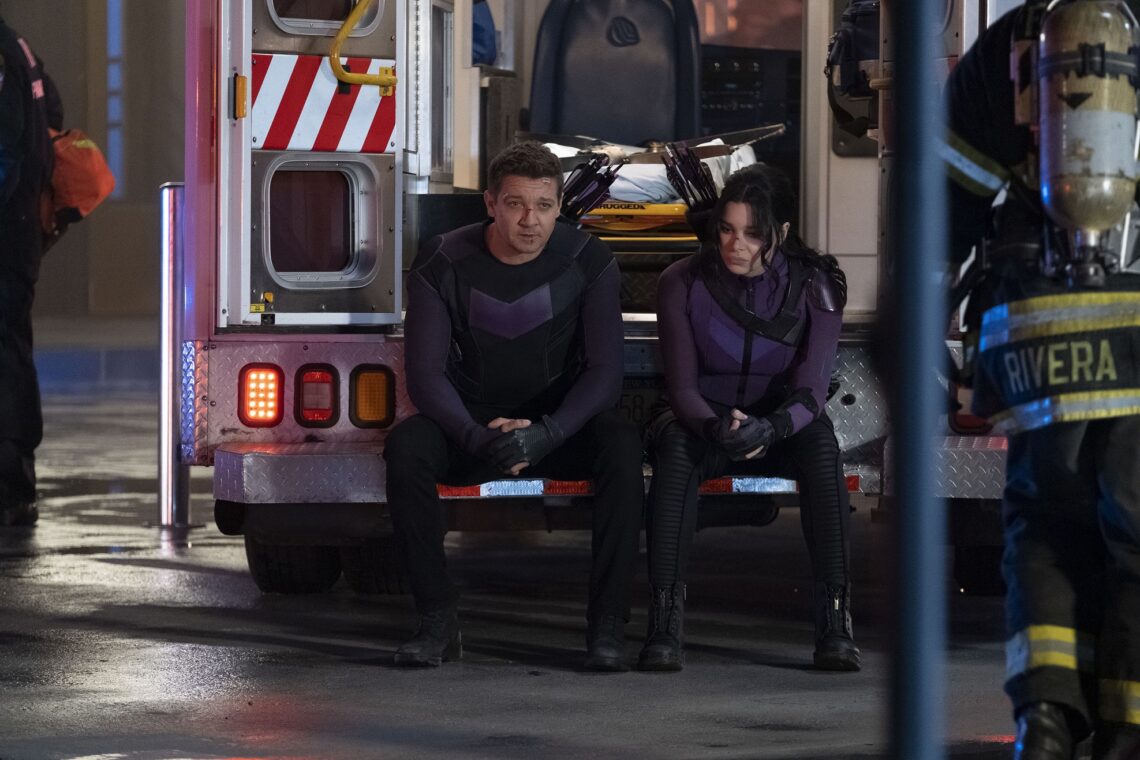 Clint Barton (Jeremy Renner) und Kate Bishop (Hailee Steinfeld) sitzen auf der hinteren Seite eines offenen Krankenwagen