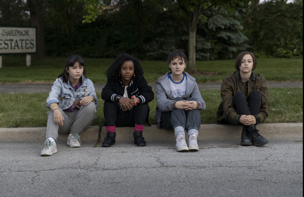 Die vier Protagonistinnen Erin, Tiffany, KJ und Mac sitzen auf der Bordsteinkante