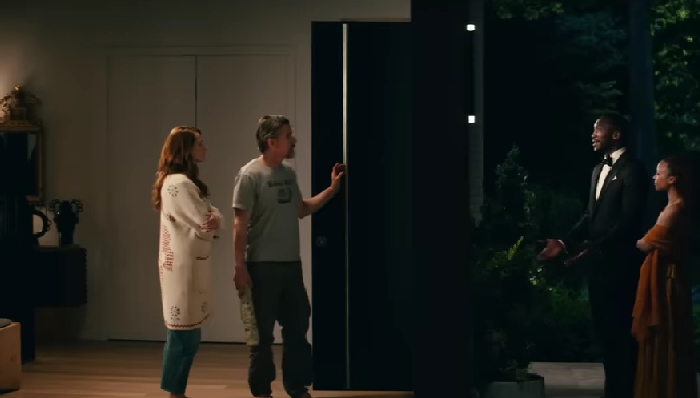 Szene aus dem Film Leave the World behind. Links sieht man die Figuren von Julia Roberts und Ethan Hawke in einem Haus an der Tür stehen, rechts vor der Tür stehen die Figuren von Mahershala Ali und Myha’la Herrold