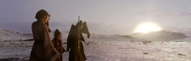 Szene aus der Serie. Man sieht drei Personen in traditionellen asiatischen Gewändern in einer kargen Landschaft stehen. Zwei halten ihre Hände vor ihr Gesicht, da am Horizont eine gleißend helle Kugel erscheint