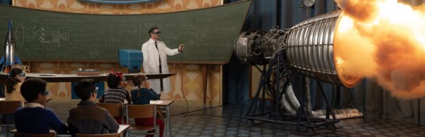 Filmszene aus Fantastic Four. Ein Mann im Laborkittel steht in einem Klassenraum und demonstriert eine Raktenantriebszündkapsel